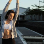 Woman in workout gear stretching.