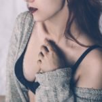 Girl in grey pull over and black bra